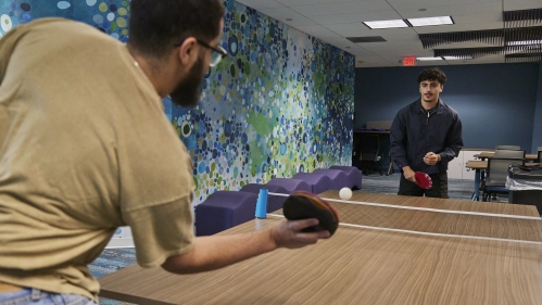 Two students playing ping pong