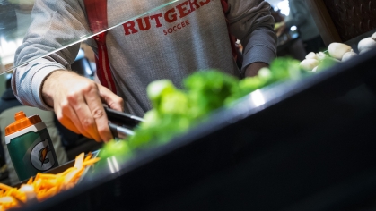 A student fills his plate at the Livingston Dining Hall