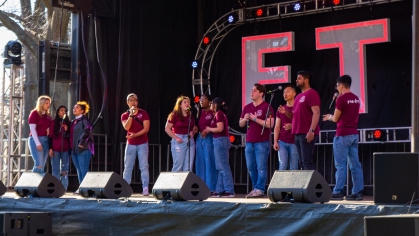 A group performs on stage at the Dance Marathon held on Voorhees Mall