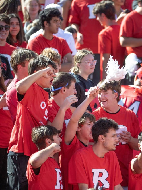 Students in the stands with the Scarlet Knight at a football game
