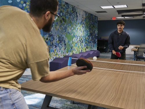 Two students playing ping pong