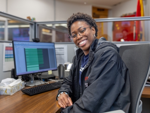 Nephtalie Brice, a student employee at the Busch Student Center, sits at a desk