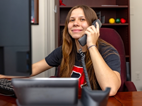 Rachel Dray talks on the phone in the Dean of Students office
